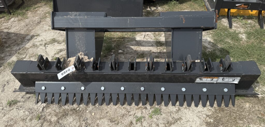 Black landscape rake attachment with tines for yard work and landscaping.