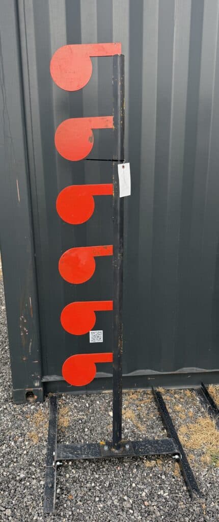 Large red measuring scale for auction display at Garrett Realty & Auction.
