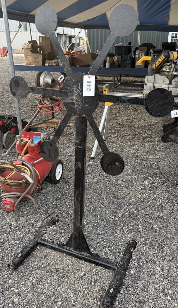 Vintage metal weather vane with directional arrows at an auction.