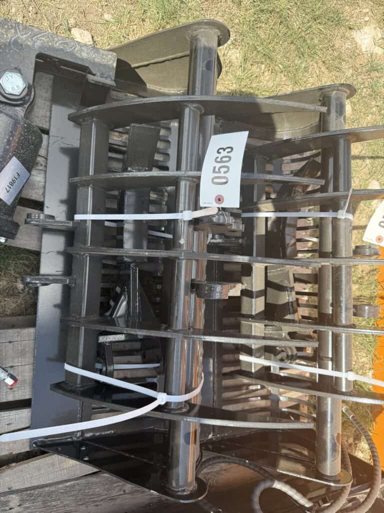 Large industrial machinery attachment with multiple metal bars and hydraulic components.
