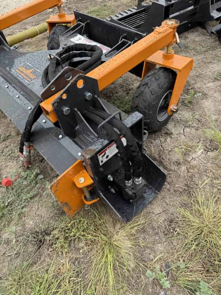 Construction equipment with orange and black parts at auction site.