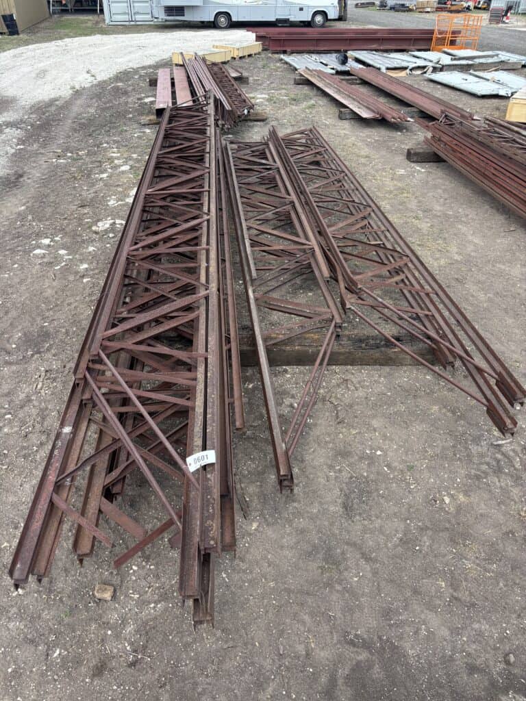 Rusty metal trusses and beams at an auction site.