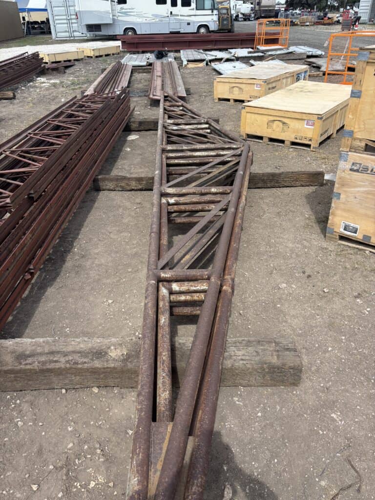 Rusty metal trusses and equipment at an auction site.
