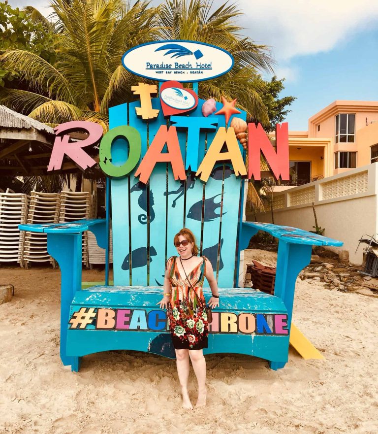 Bright Paradise Beach Hotel sign at Roatan beach destination.