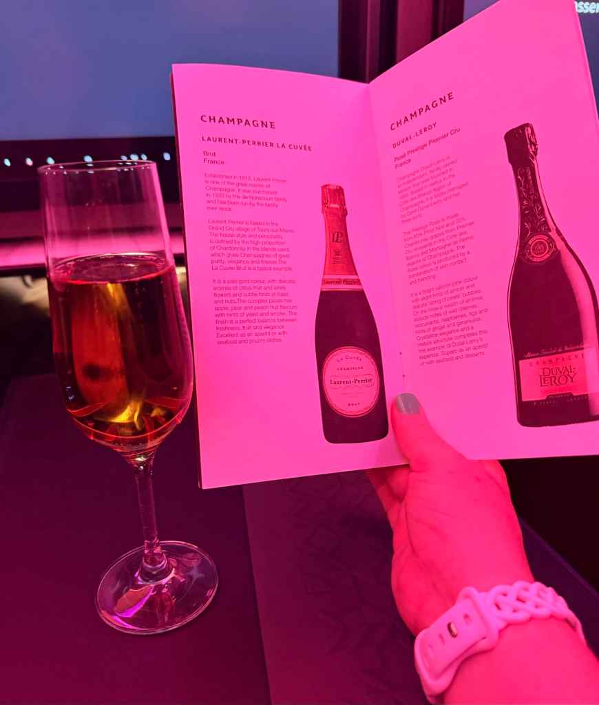 Champagne glass and brochure featuring Laurent-Perrier champagne bottles.
