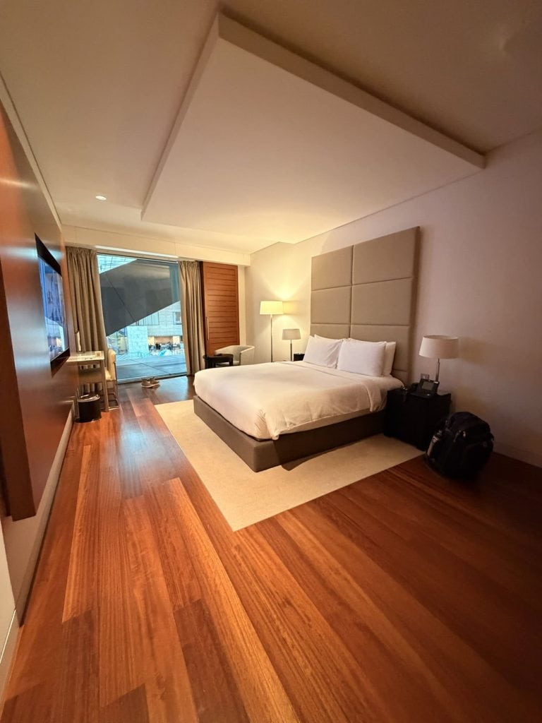 Luxury hotel room with a large bed, modern furnishings, and a balcony view.