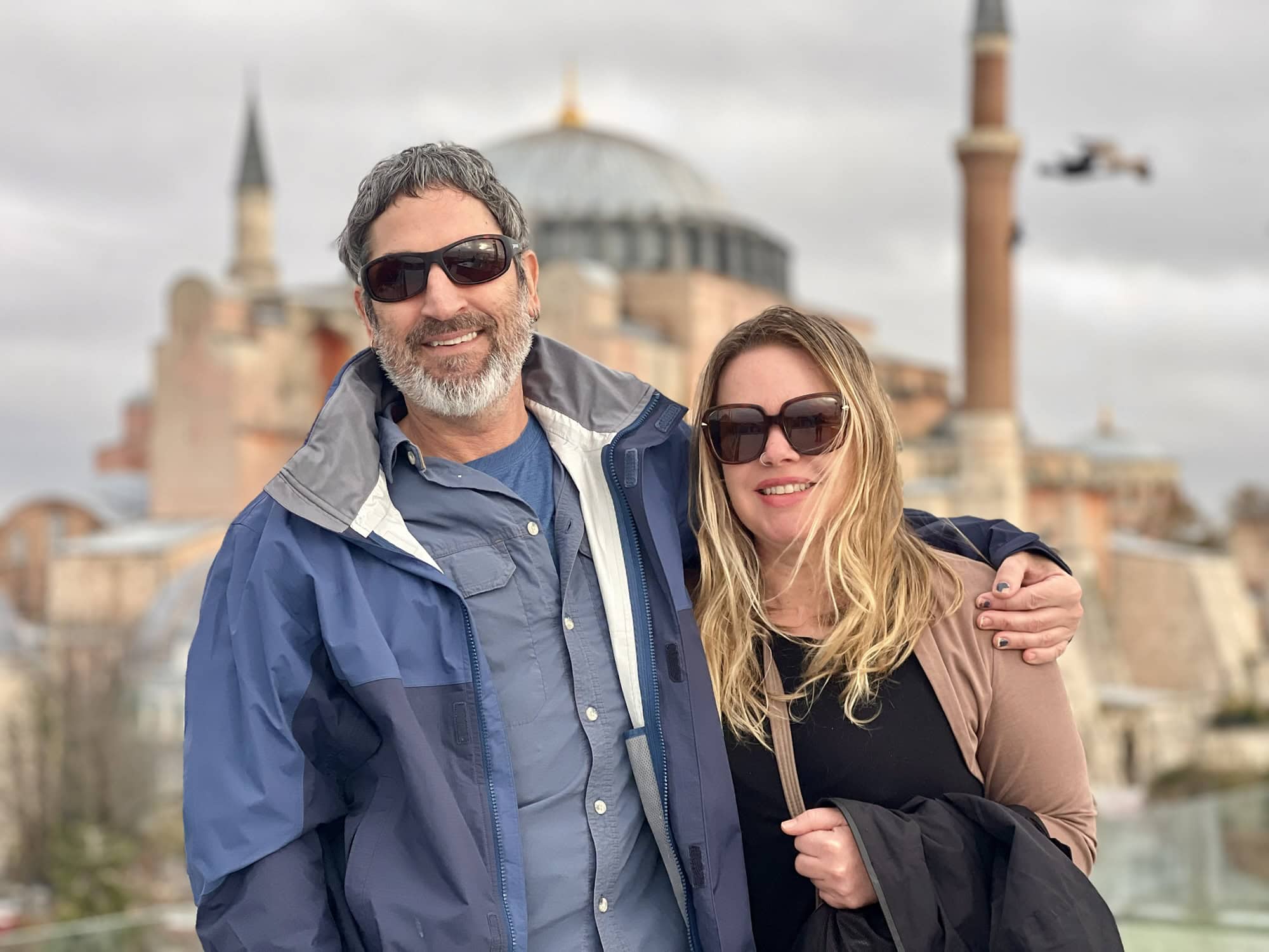 Traveling couple exploring Istanbul, Turkey, with the Hagia Sophia in the background. Enjoying a mem.