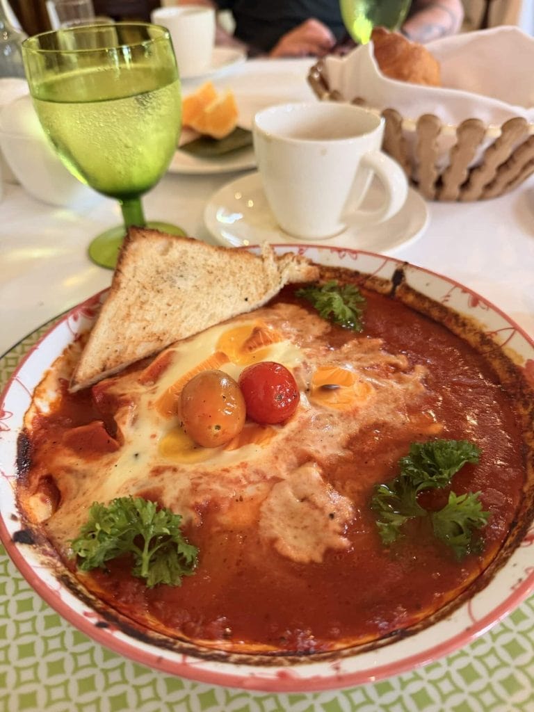 Eggs baked in tomato sauce with cherry tomatoes and herbs, served with toasted bread. Perfect for a.