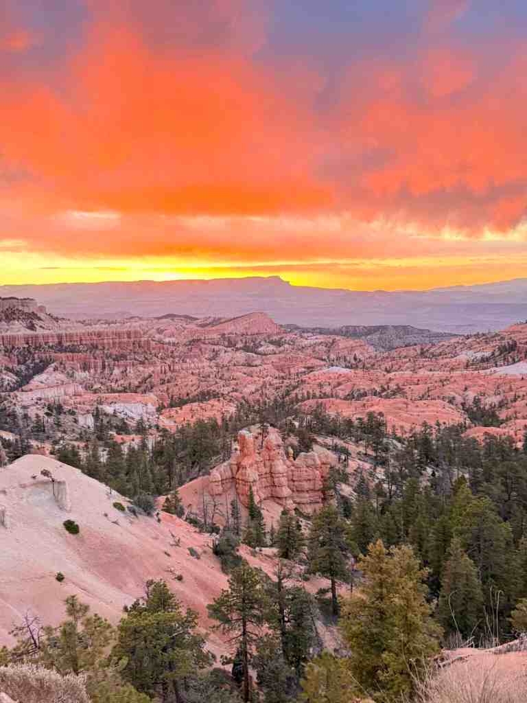 Sunset illuminating Bryce Canyon's unique rock formations and vibrant sky.