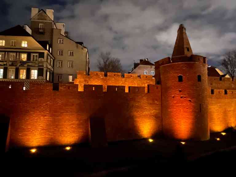 Historic city wall illuminated at night in Europe.