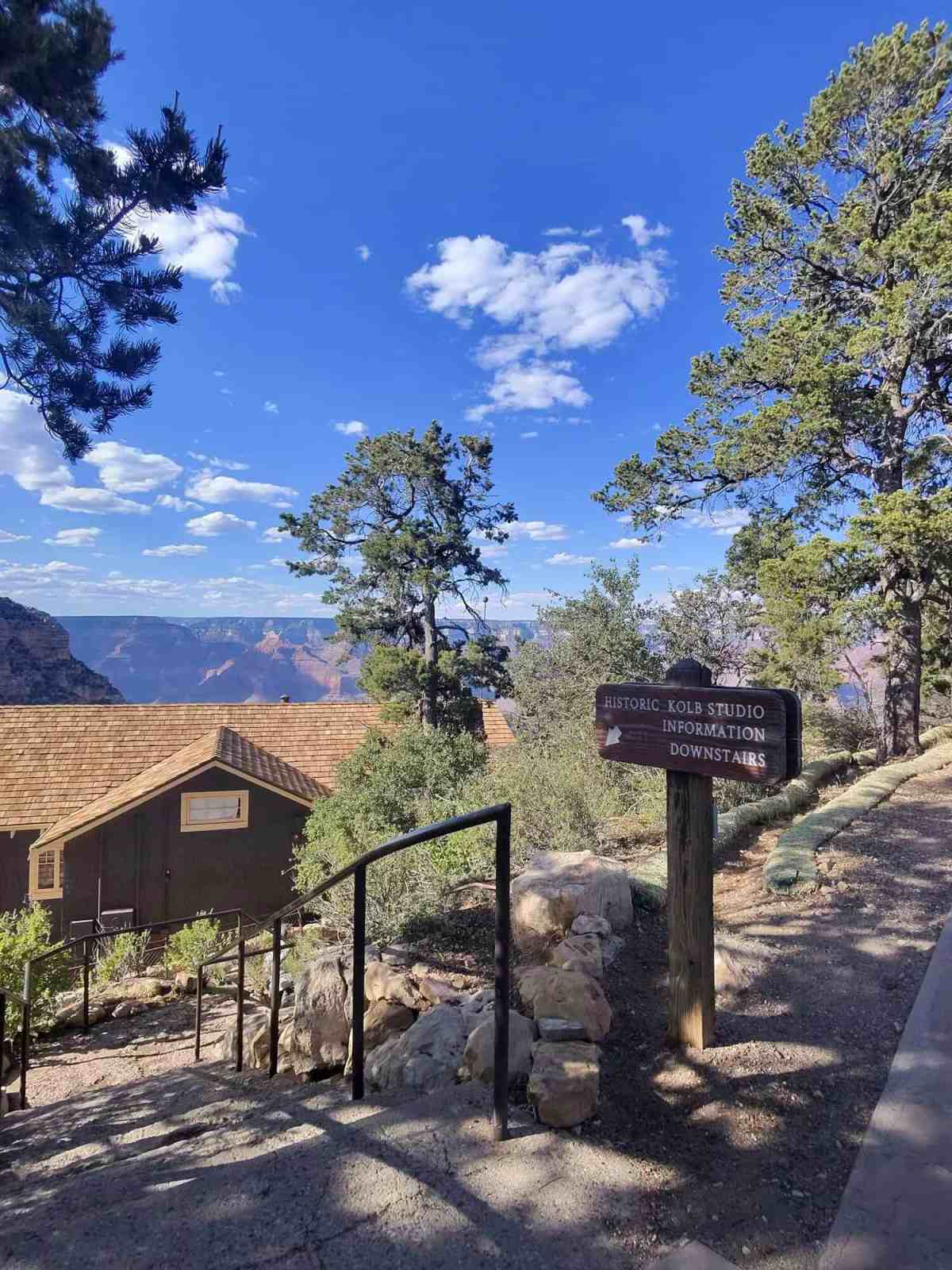 Grand Canyon hiking trail with informational sign and scenic landscape.
