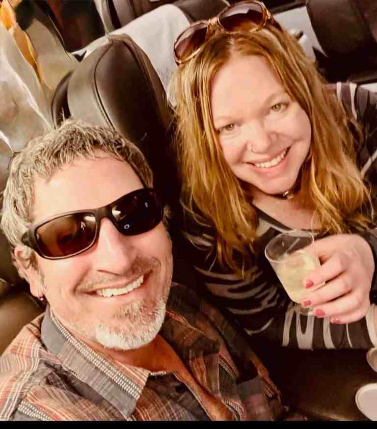 Happy couple enjoying travel, smiling with drinks in hand.