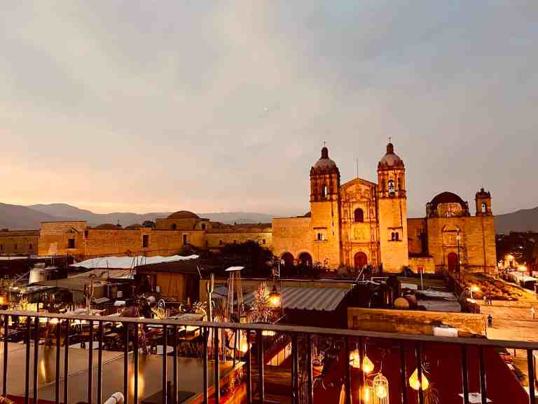 Historic cityscape at sunset with cathedral and market scene.