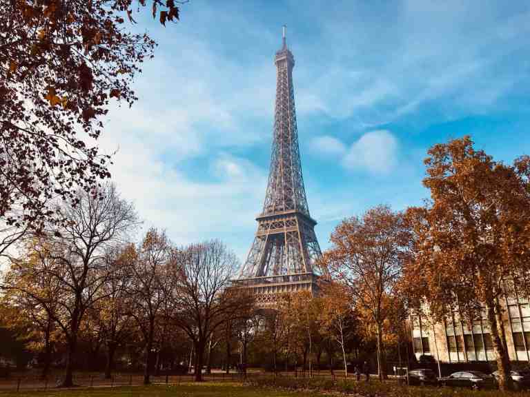 Eiffel Tower in Paris with autumn trees in foreground.