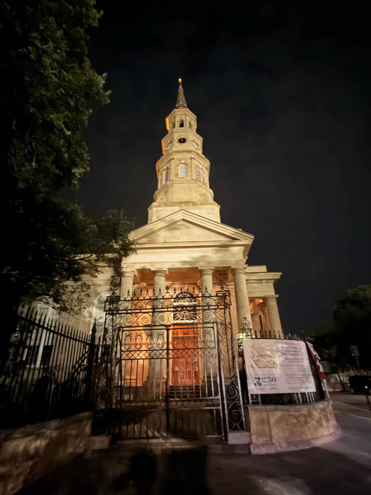 Night view of historic church with illuminated tower and classical architecture.