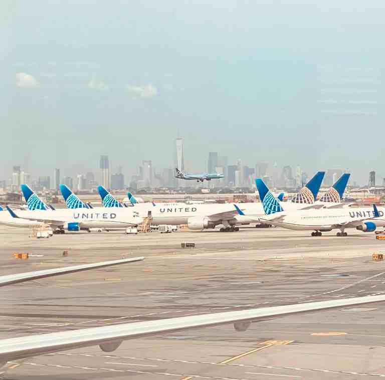 United Airlines planes on runway with New York City skyline in background.