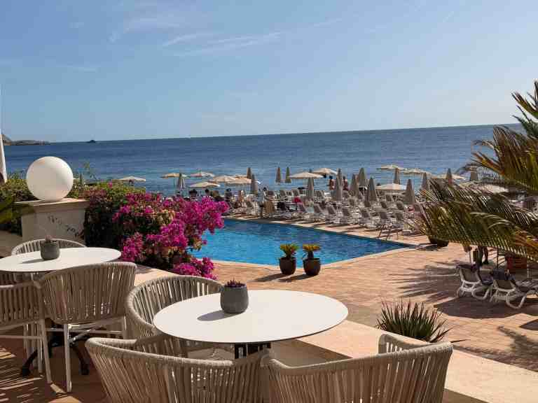 Seaside resort with pool, lounge chairs, and ocean view for travel blog.