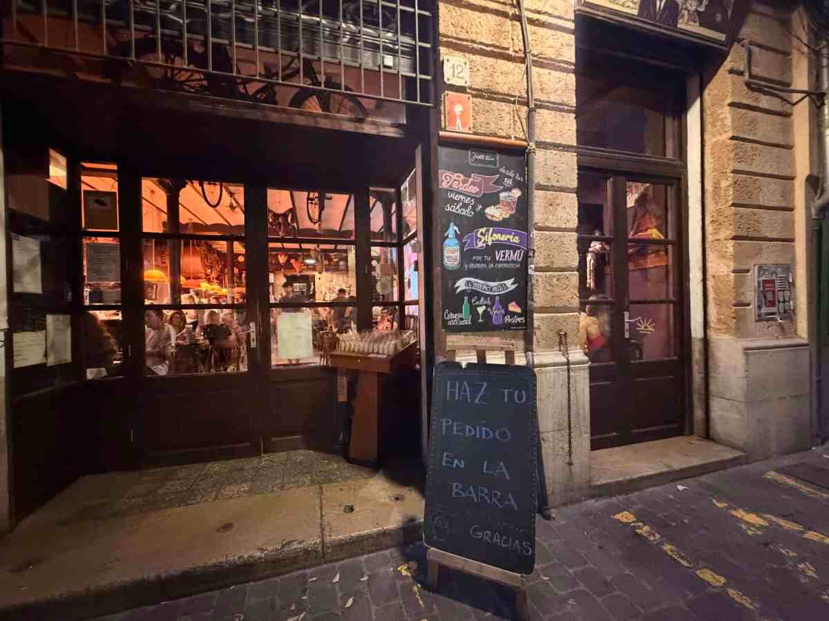 Cozy restaurant exterior with chalkboard menu and warm interior lighting.