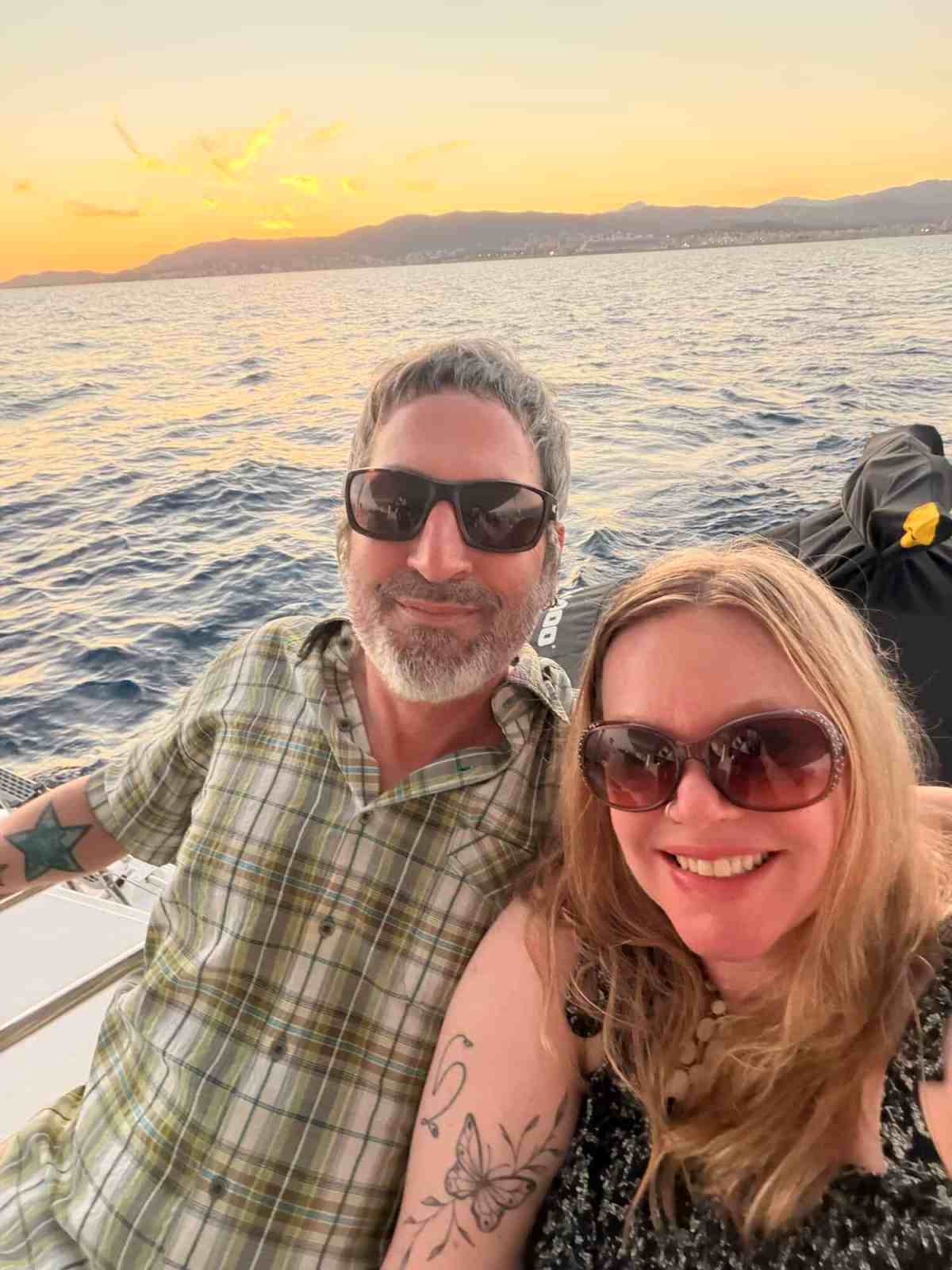 LiAnn and Theo enjoying a sunset cruise on the water with scenic mountains in the background.