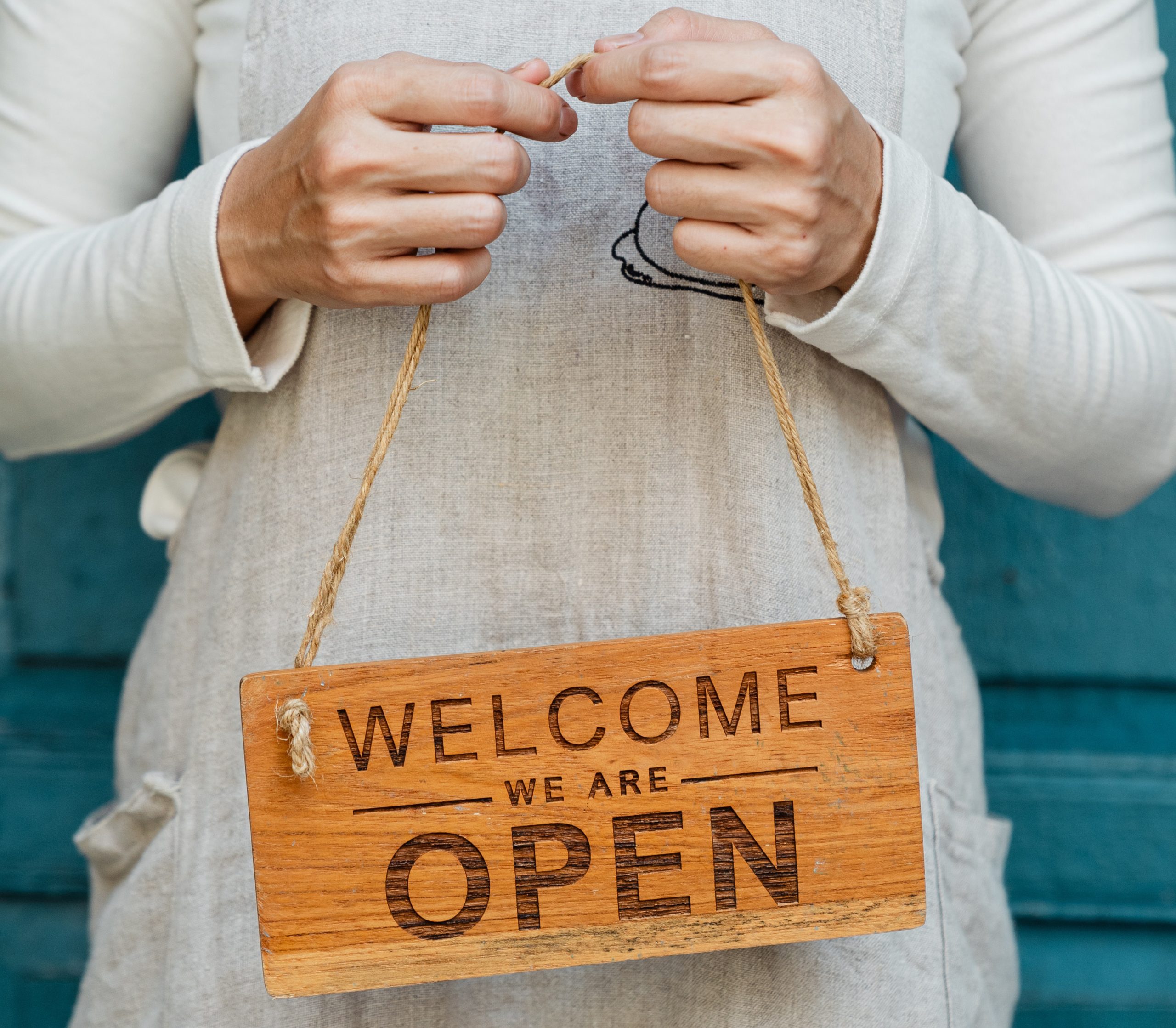 A business owner proudly displaying their newly opened business signage.
