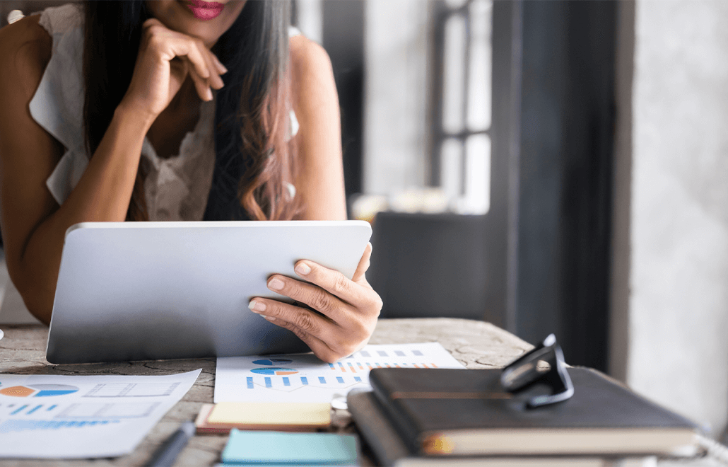 A marketing professional utilizing a tablet to strategize and implement effective outreach campaigns for the year 2024.