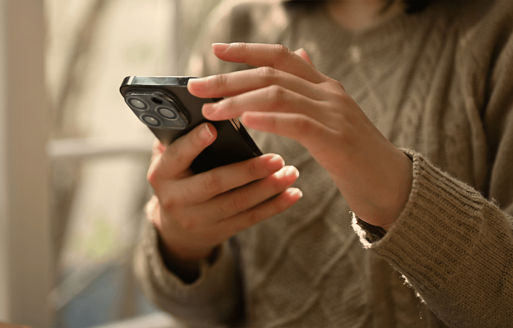 A millennial woman using her smartphone to stay connected and access digital information.