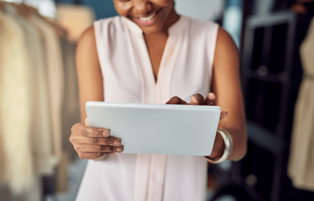 A smiling businesswoman using a tablet to manage her business efficiently.