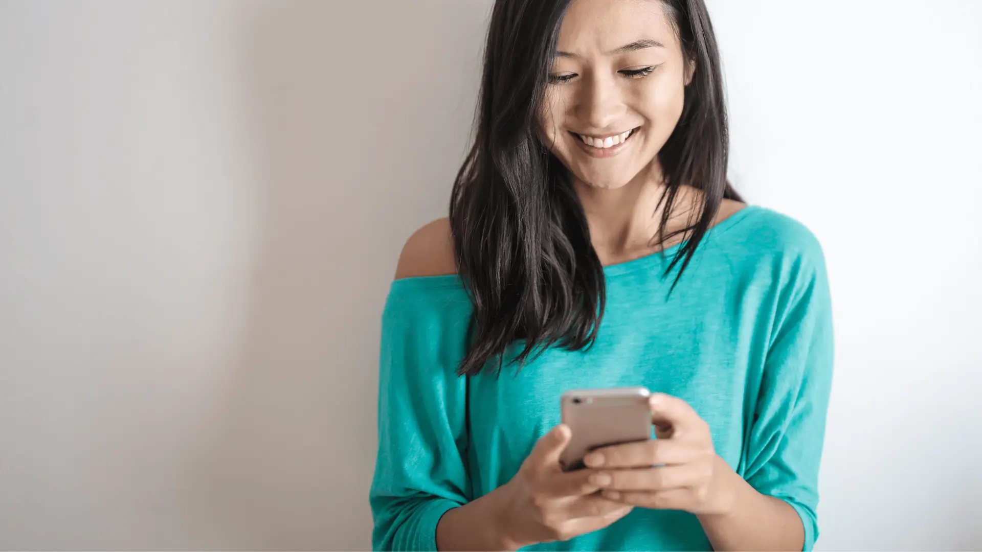 Happy woman easily browsing on her phone, highlighting the importance of mobile optimization for a positive user experience.