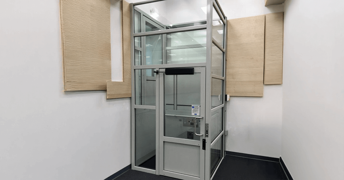 Enclosed vertical platform lift installed at a commercial building entrance in Dallas-Fort Worth