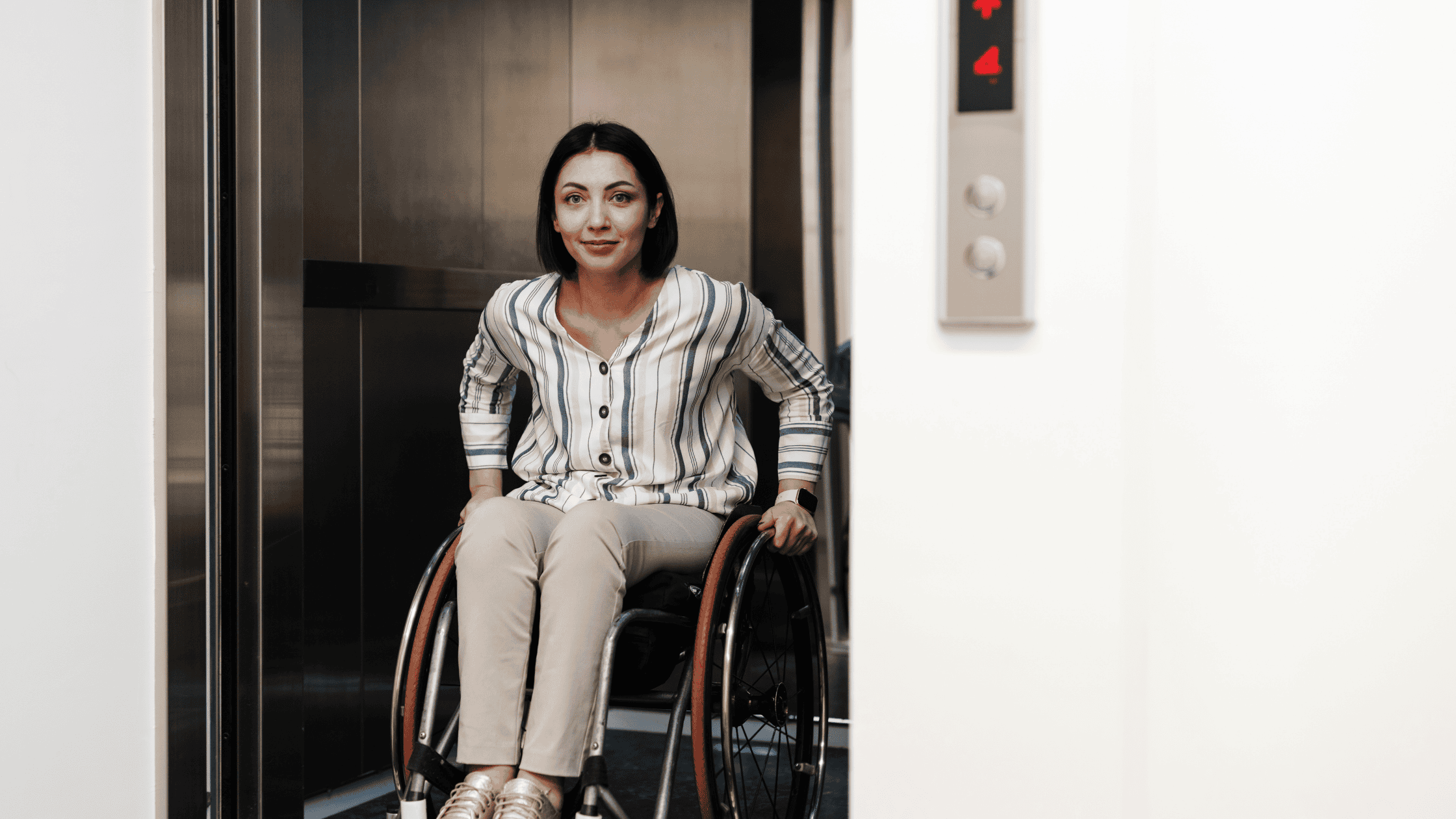 A wheelchair user riding inside a spacious Elvoron home elevator cab sized for a wheelchair and caregiver in a North Texas home