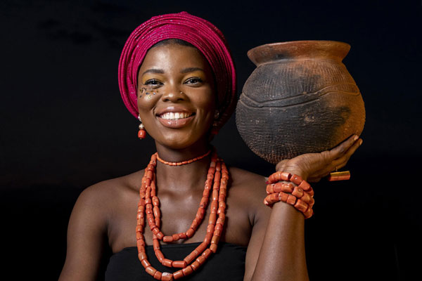 Femmes africaine avec bijoux traditionnels et pot en terre, portrait en studio.
