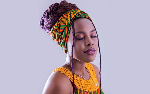 Lapidation d'une femme africaine avec un pagne coloré et un turban traditionnel, beauté ethnique et mode africaine.
