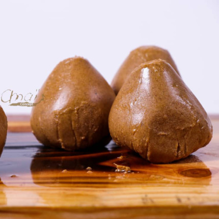 Truffes en chocolat brun sur planche en bois, fond blanc.