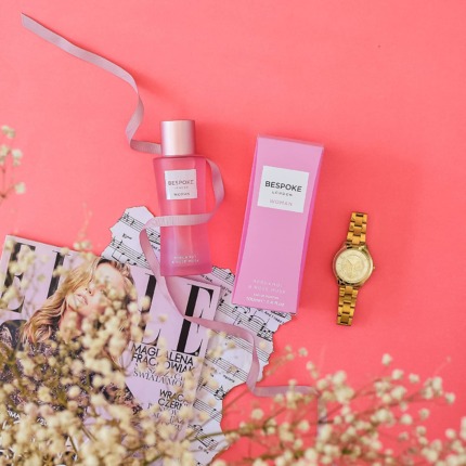 Bottles de parfum Bespoke London Woman bergamote et rose musquée sur fond rose avec montre or.