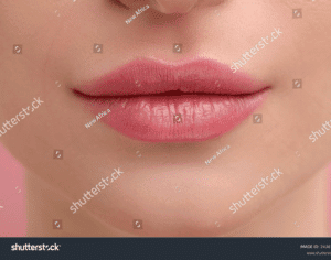 Close-up of soft pink lips after lip blushing treatment.
