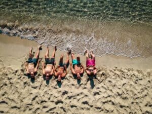 Friends lying on a sunny beach in summer