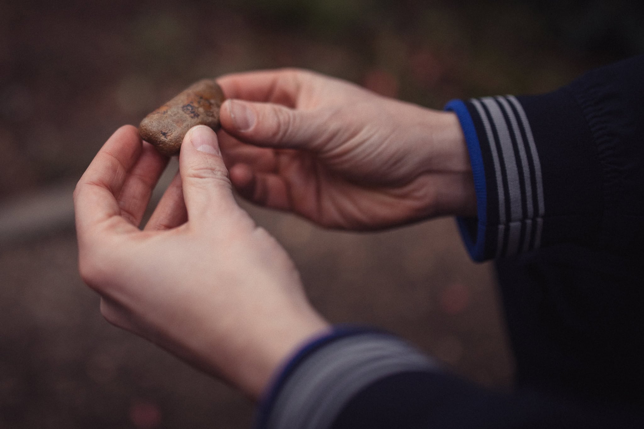 Phil Askew, London brand photographer, holding a small stone with care.
