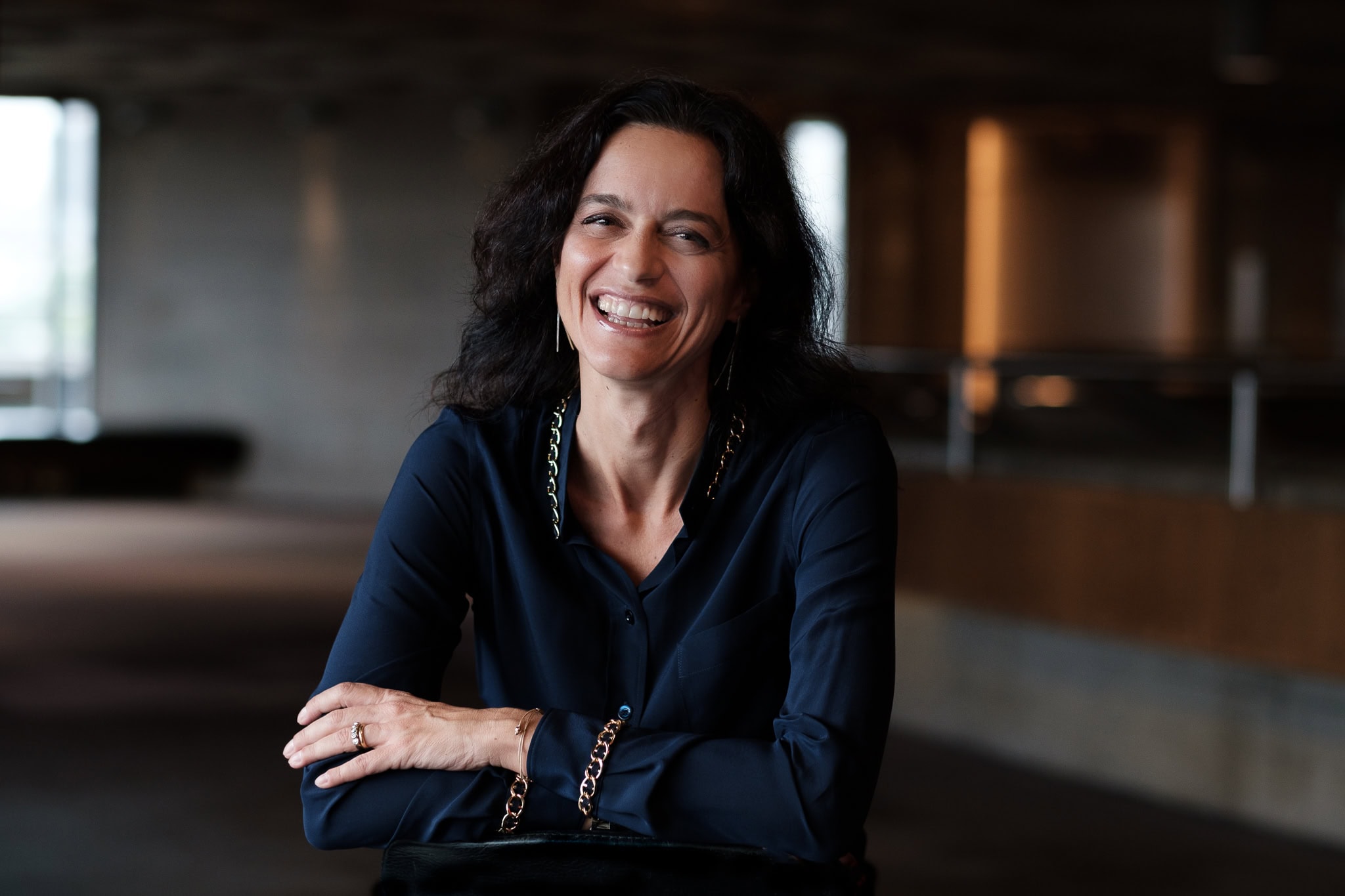 Vittoria Zipoli, a confident leader, smiles warmly in a modern London setting, captured by a London brand photographer.