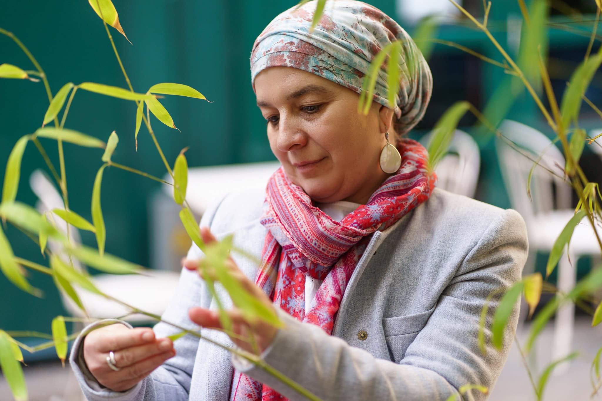 London brand photographer Phil Askew captures a woman in a headscarf and blazer, thoughtfully examining bamboo.