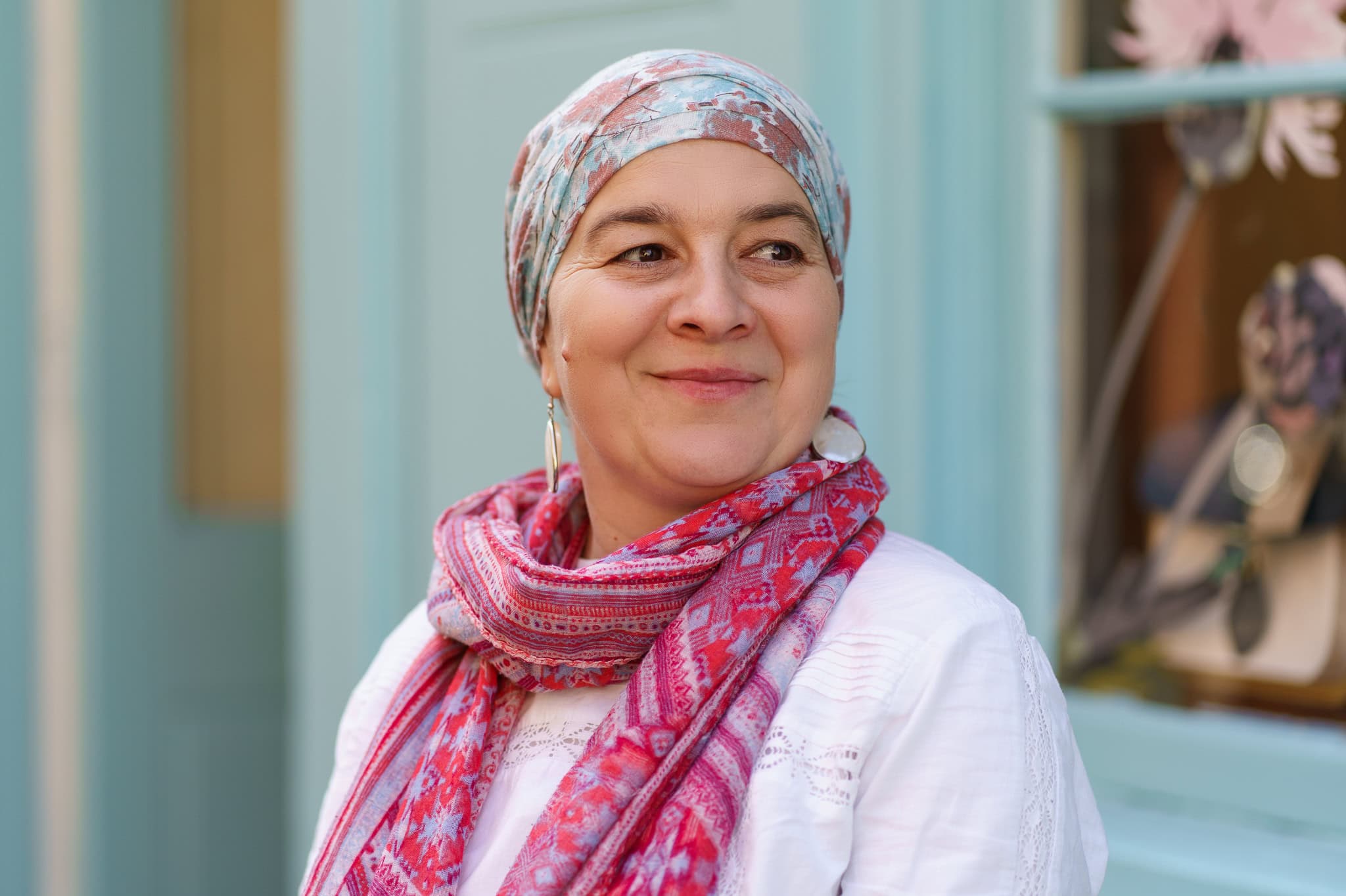 Authentic portrait of a woman wearing a colourful headscarf and scarf, with soft light. London brand photographer.
