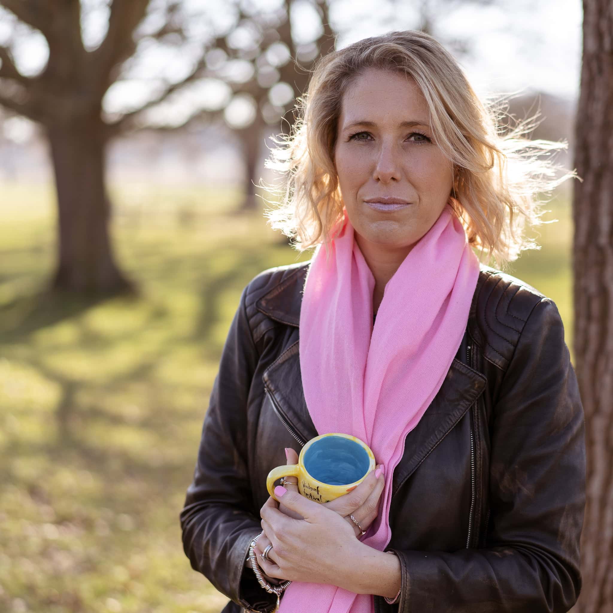 Jo Garside, a confident coach, in soft sunlight holding a yellow mug.