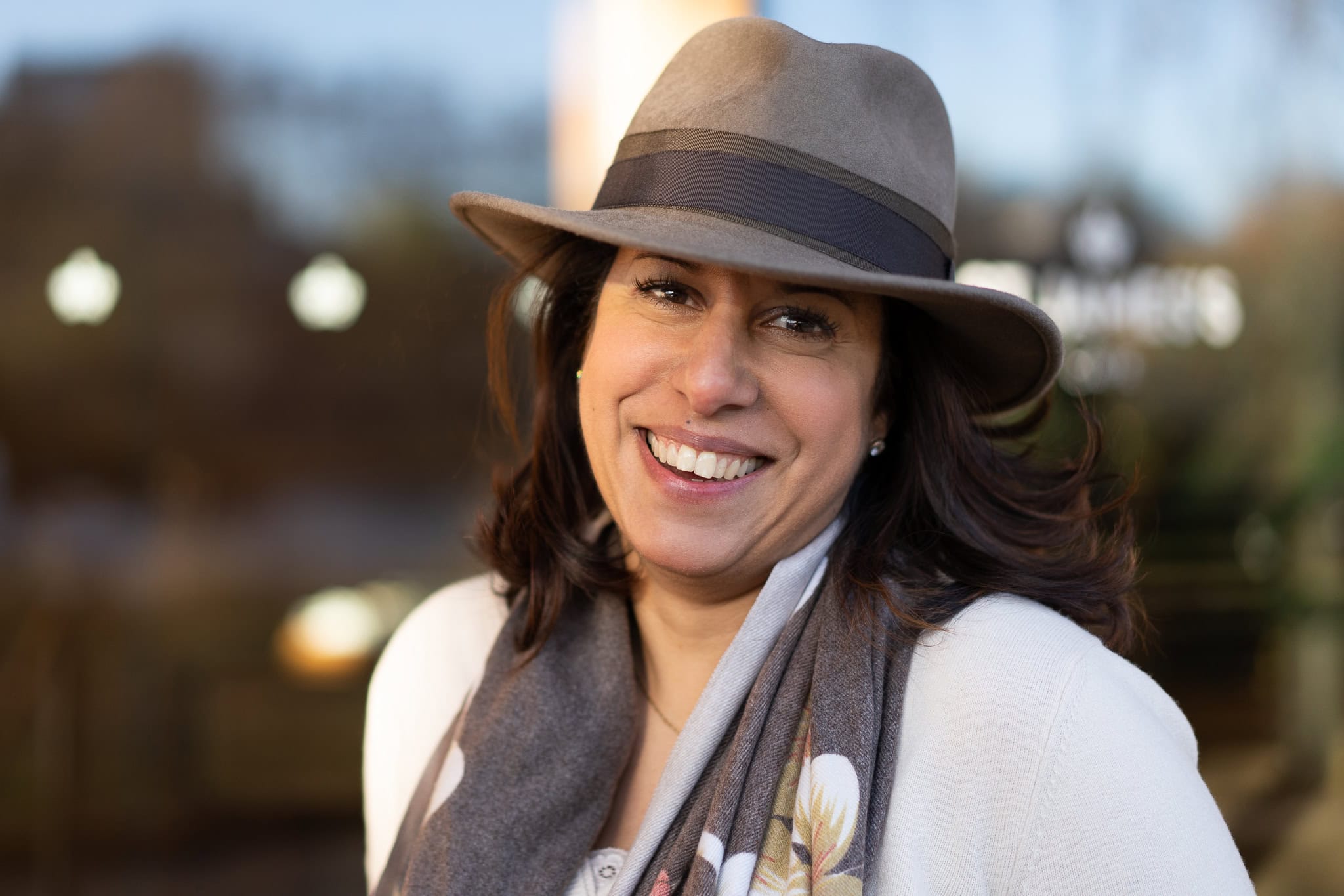 Eleonora Chessa, a confident woman with a warm smile, in a stylish hat and scarf, captured by a London brand photographer.