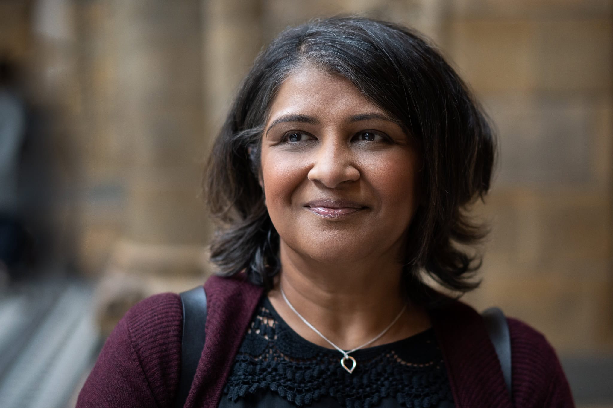 Anita Patel, a confident woman with a warm smile, photographed in London by a brand photographer.