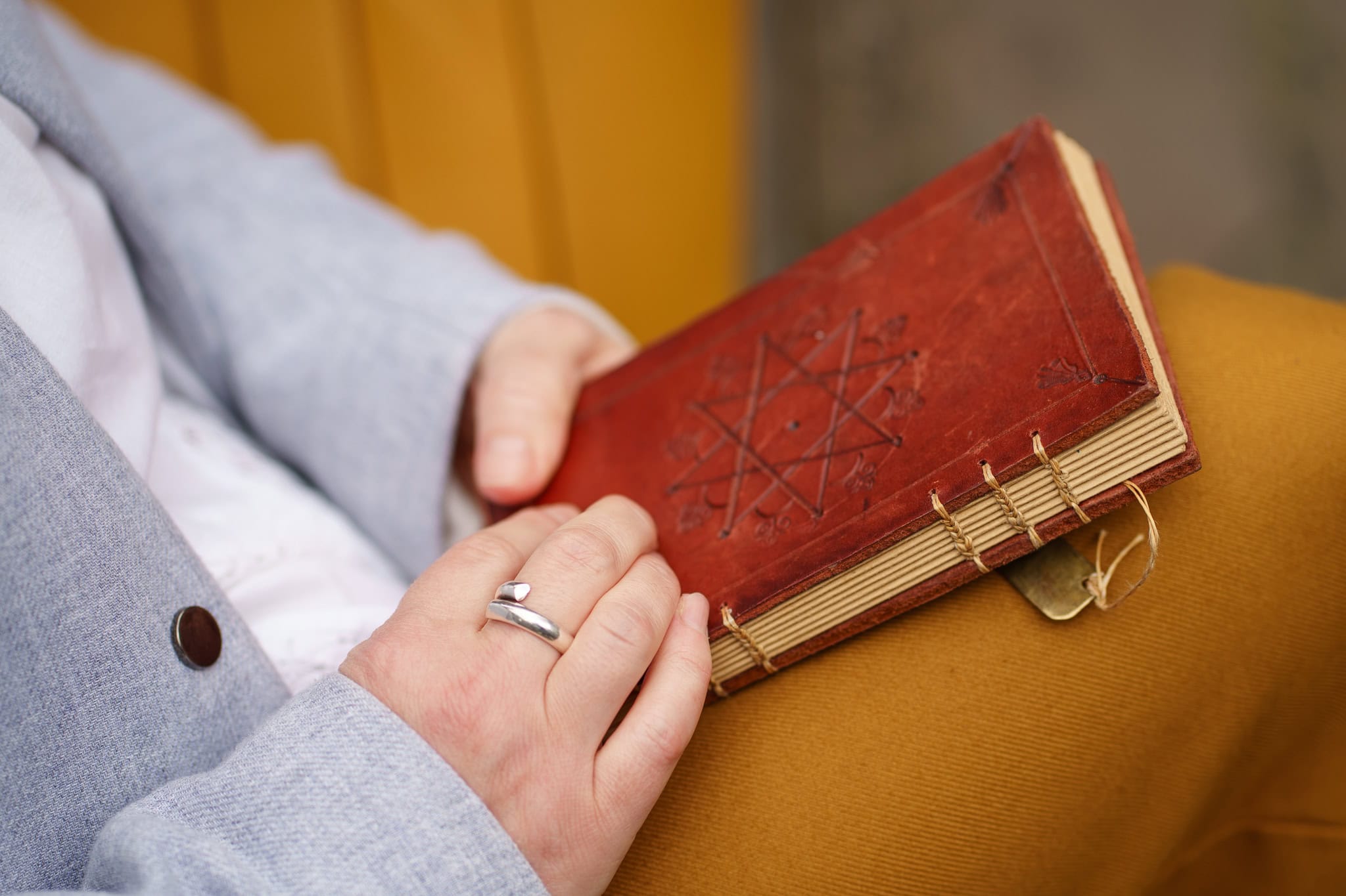London brand photographer Phil Askew captures a client holding a vintage leather-bound book, embodying authentic presence.
