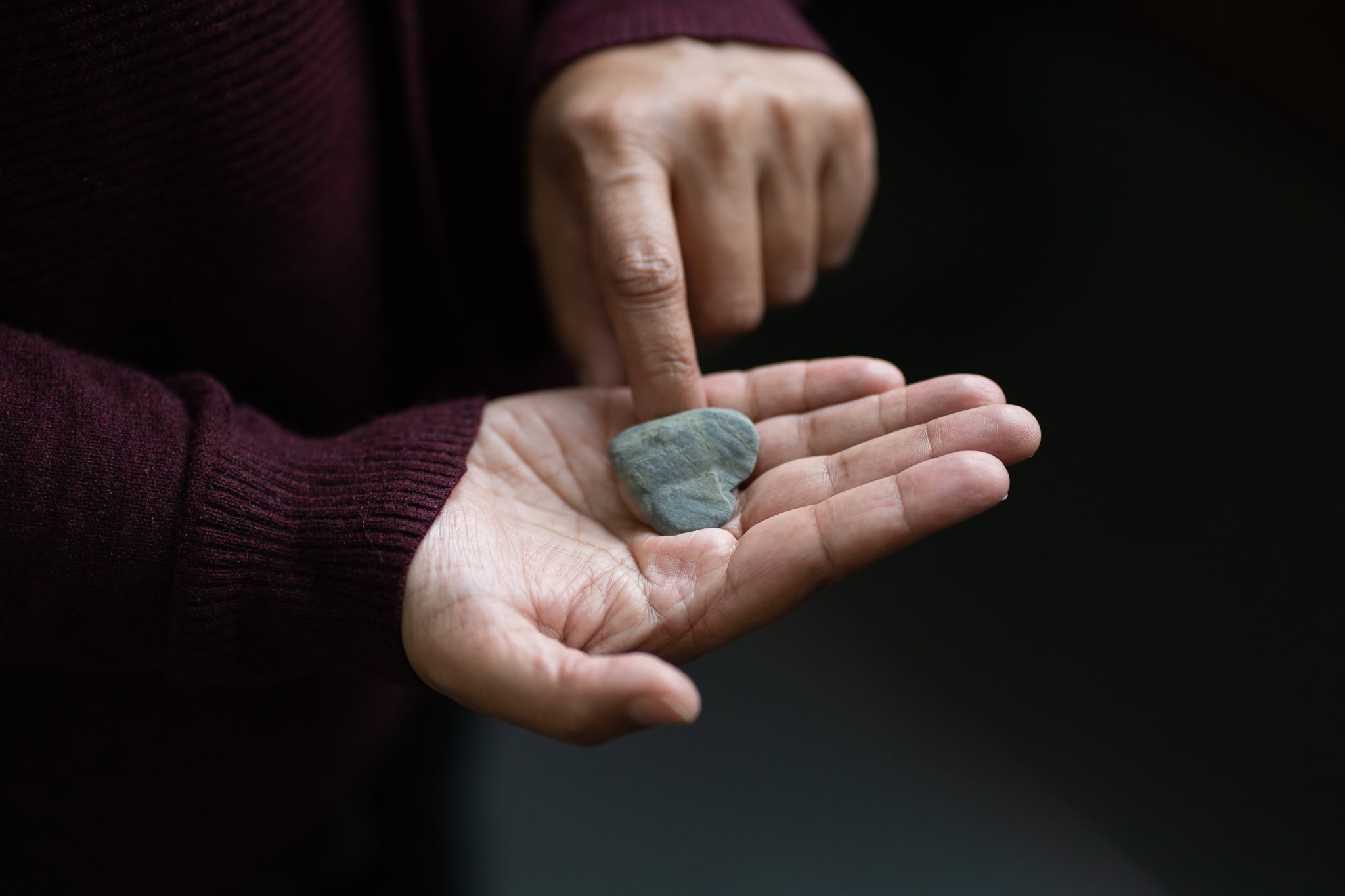 Anita Patel gently touches a smooth, grey stone held in her palm.