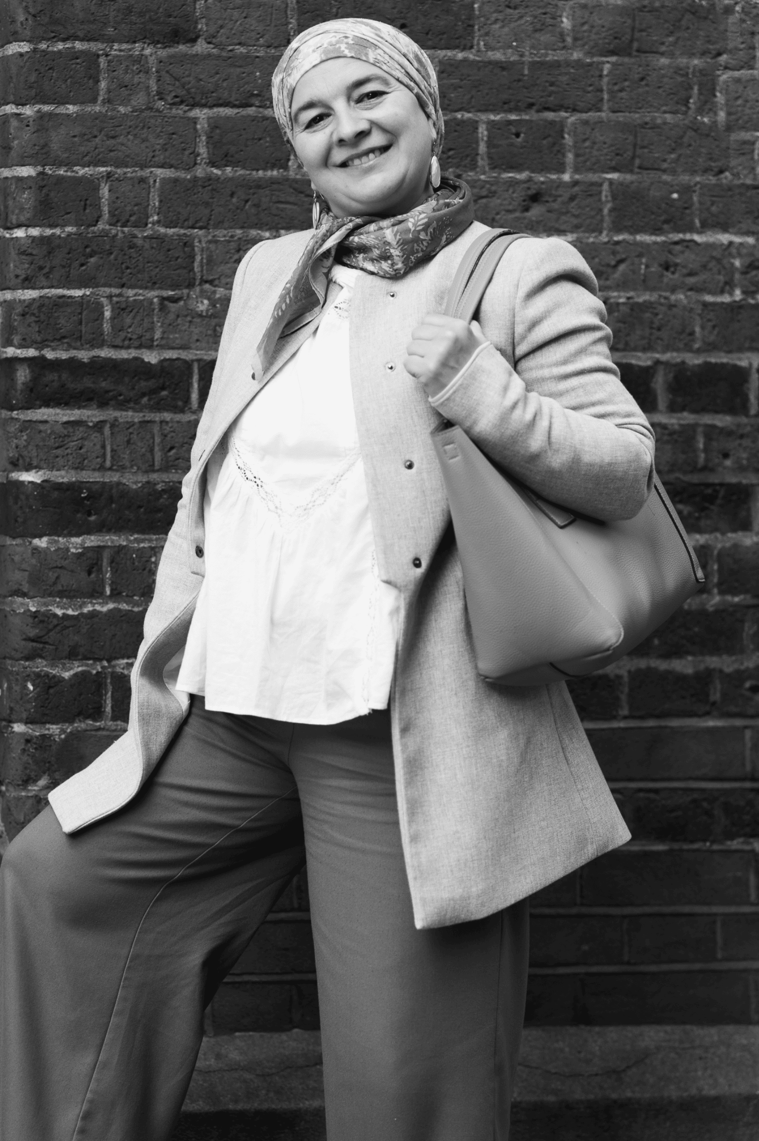 Phil Askew, London brand photographer, captures a confident woman in a stylish grey jacket and patterned headscarf.
