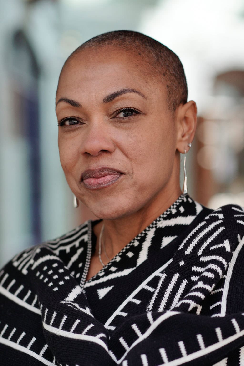 Sharlene Jones, a woman with a shaved head and a striking patterned scarf, photographed by a London brand photographer.