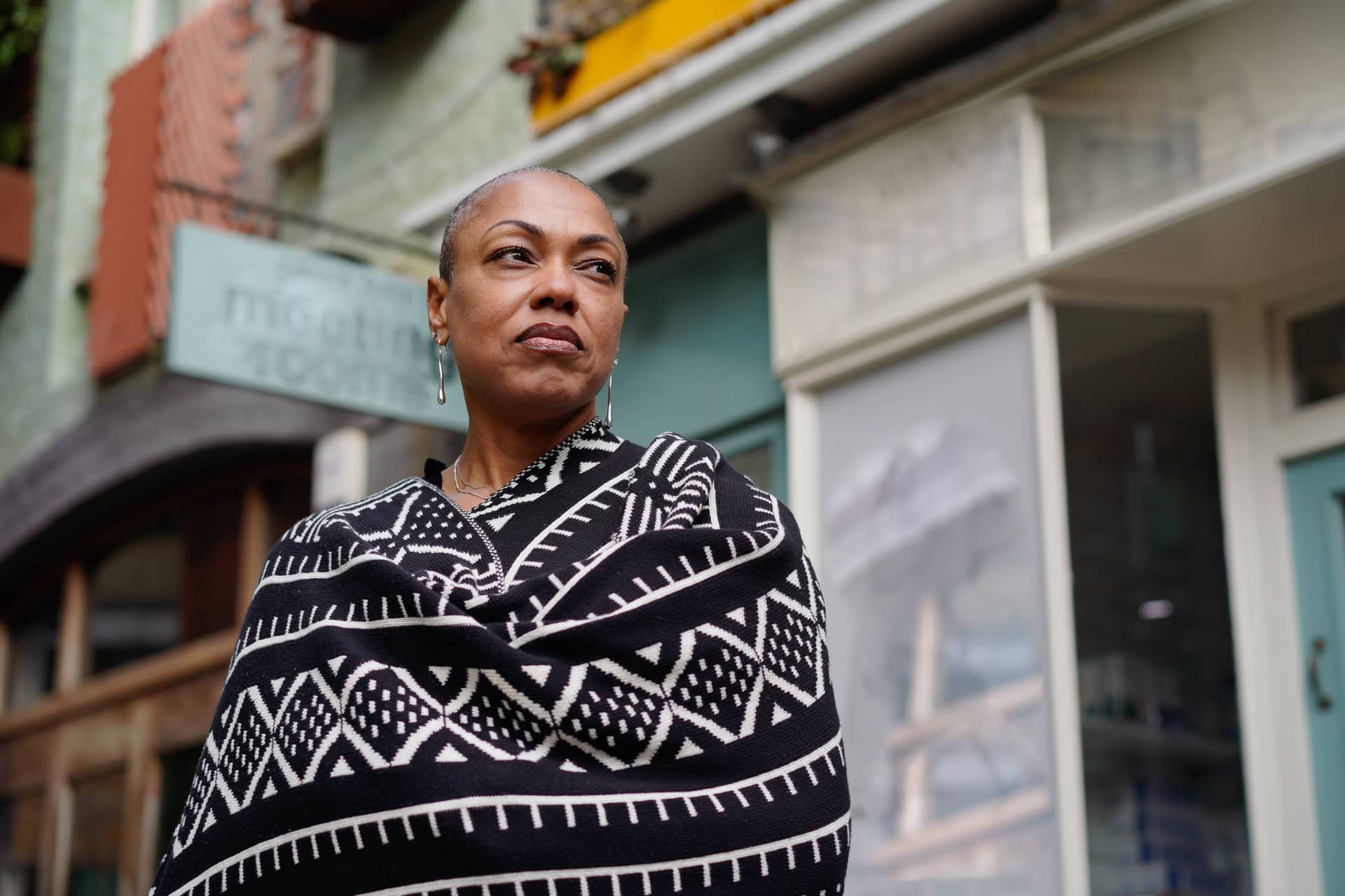 Sharlene Jones, a confident leader, poses in a London street, captured by a London brand photographer.