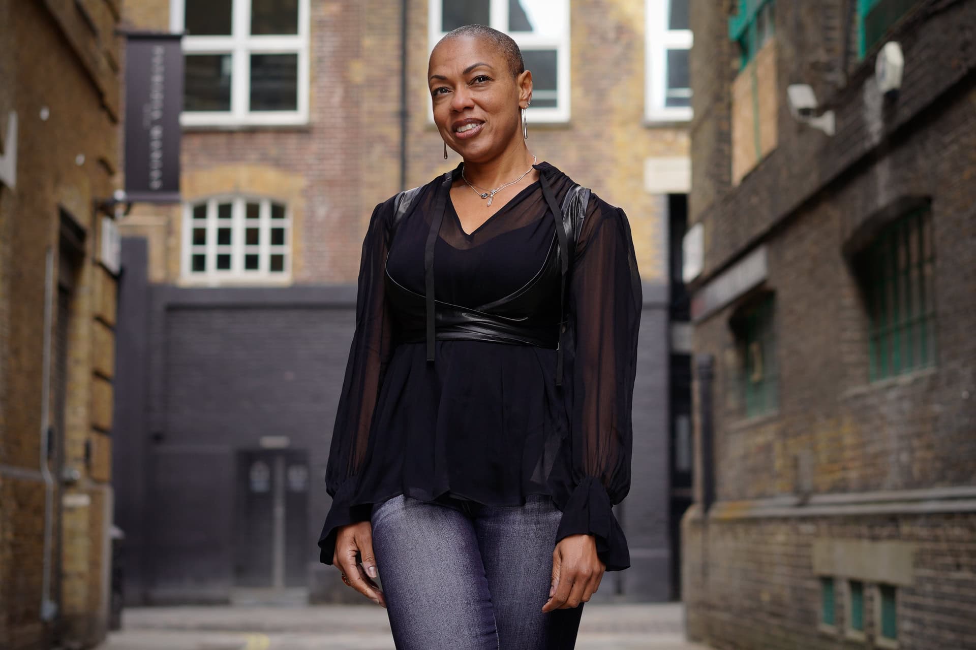 Sharlene Jones, a confident woman, poses in a London alley, captured by London brand photographer Phil Askew.