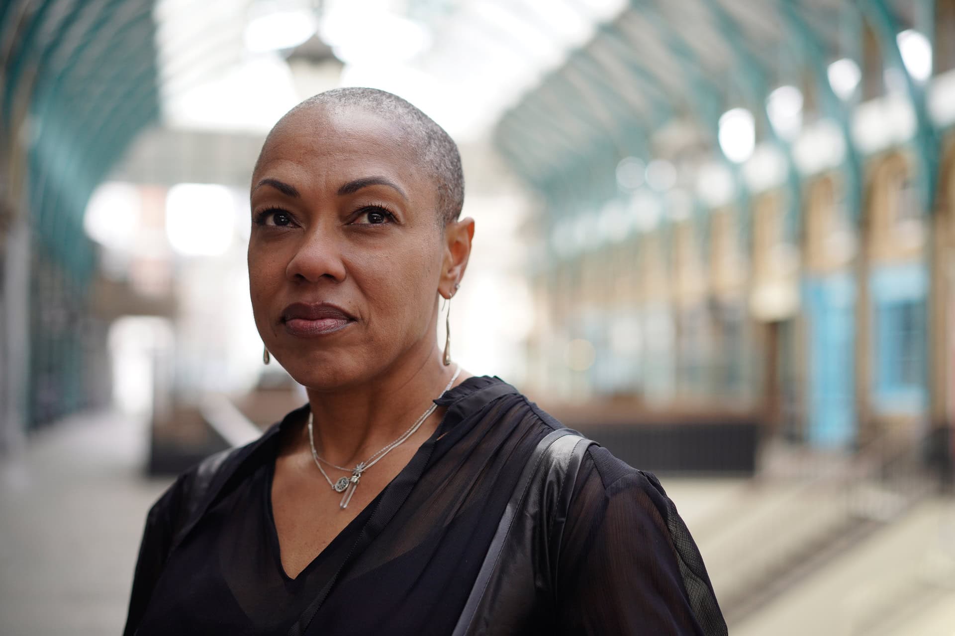 Sharlene Jones, a confident woman, photographed in a bright London arcade by a brand photographer.